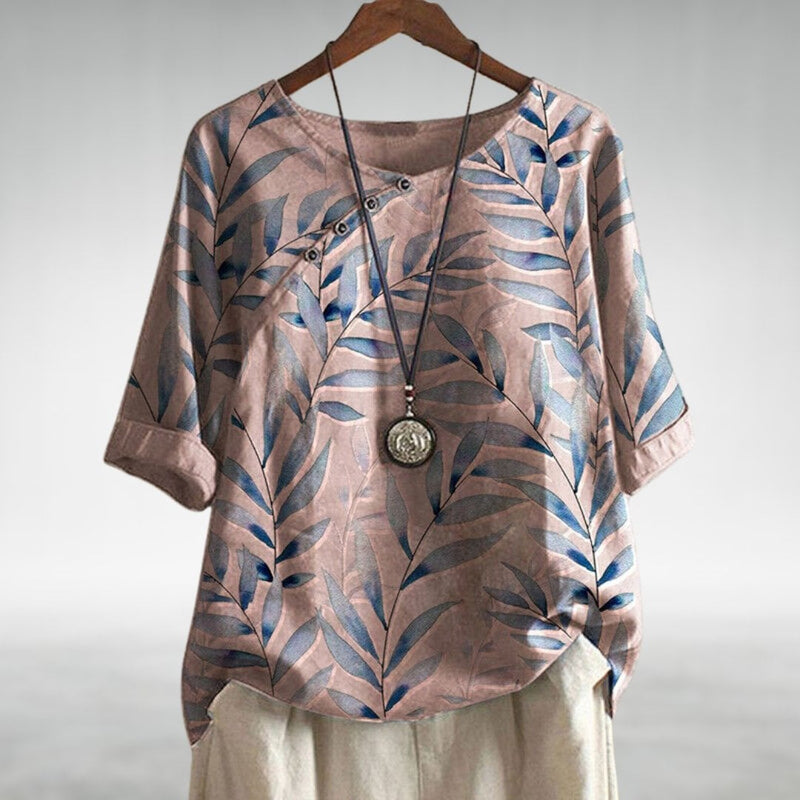 Close-up of the asymmetric button detail on a lightweight flowing women's blouse