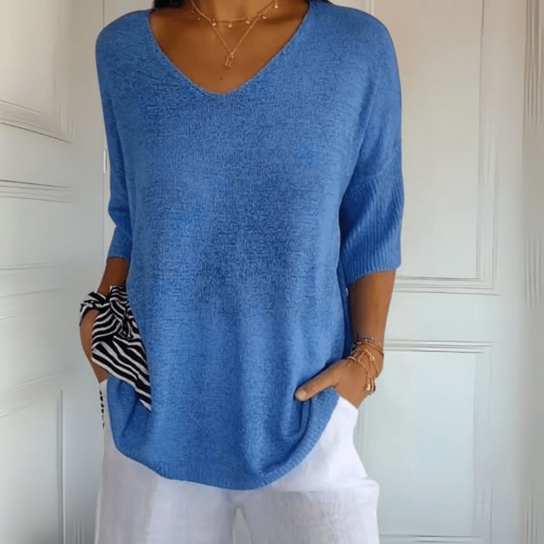 Detail shot of V-neckline on a soft knit top in green, highlighting fabric quality and finish