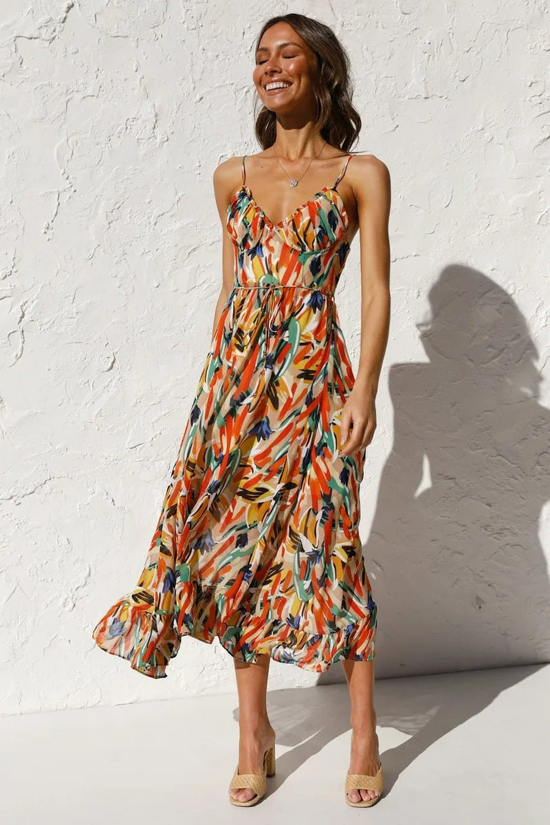 Model wearing the TropicLush Elegant Dress in vibrant orange with a bold tropical print, front view