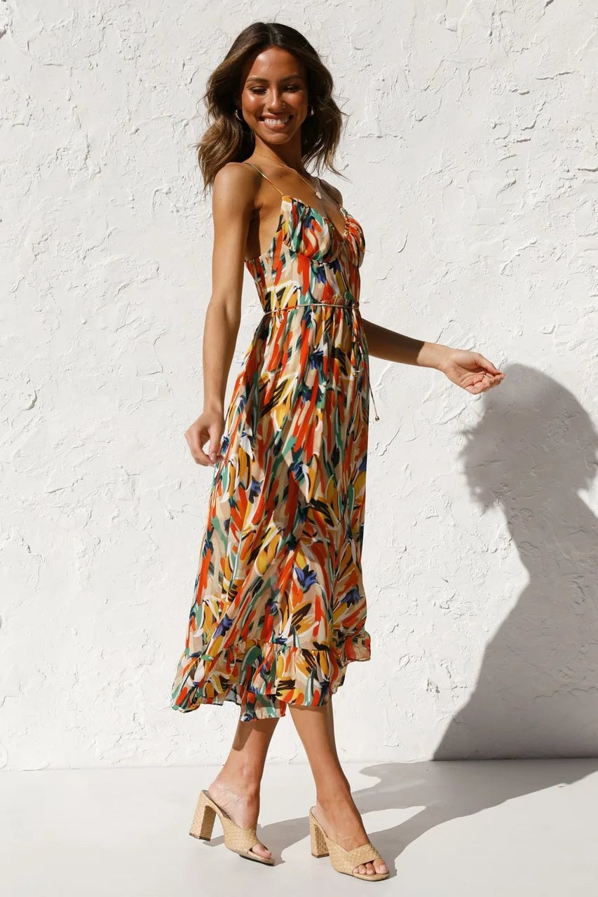 Side view of the TropicLush Elegant Dress in orange highlighting the lightweight fabric drape