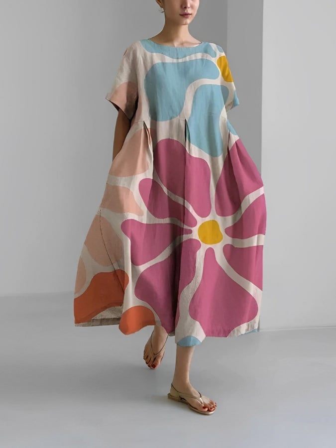 Front view of the Valentina floral print dress showing the airy swing cut, short sleeves, and full-length hem in a casual outdoor setting
