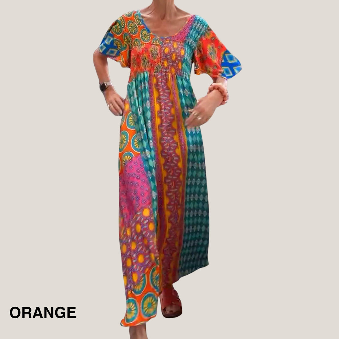 Model wearing an elegant paisley midi dress with a round neckline in a vibrant orange print, styled with sandals