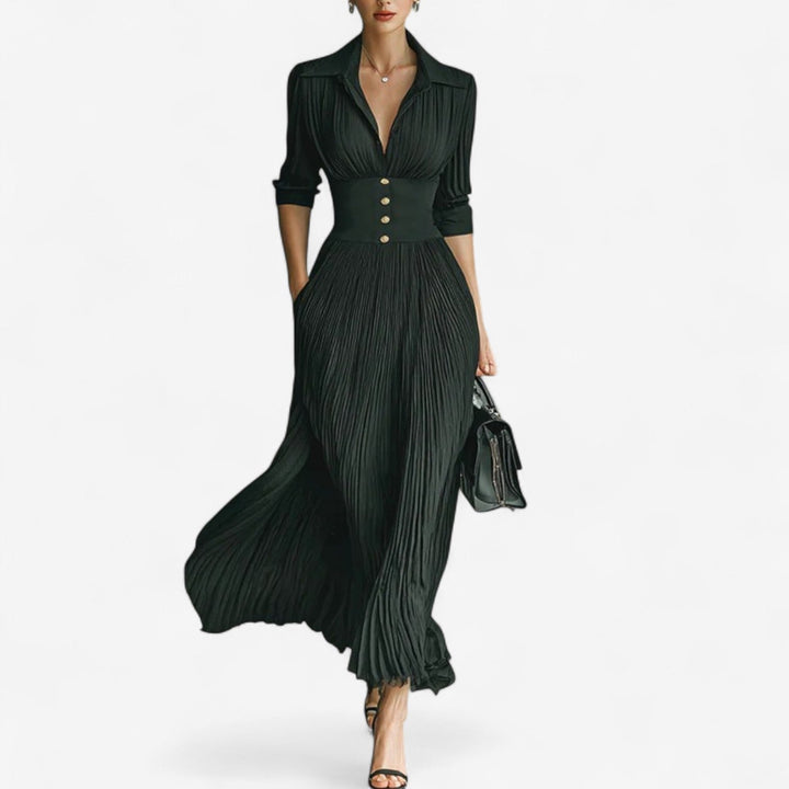 Woman wearing a black maxi pleated dress with flowing cascading pleats and a long elegant silhouette