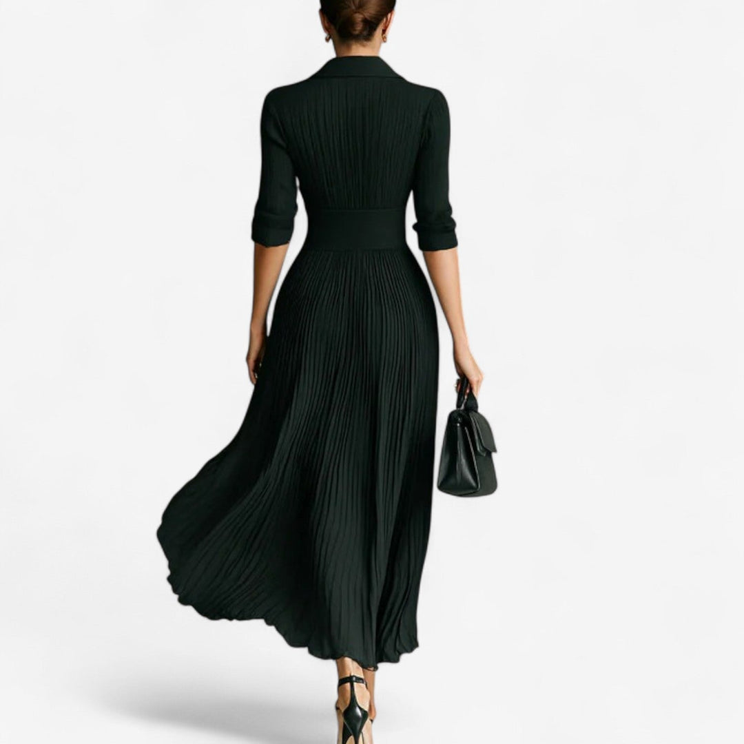 Close-up of the soft pleated fabric detail on a black maxi dress showing texture and movement