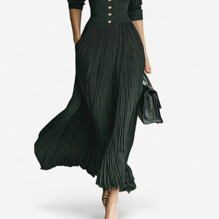 Full-length view of a black maxi pleated dress styled for a formal occasion