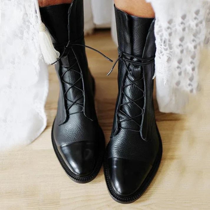 Black pointed-toe vintage-inspired boots with a sleek silhouette, front view