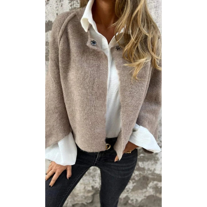 Woman wearing an elegant long coat with a round neckline and long sleeves in a neutral beige tone