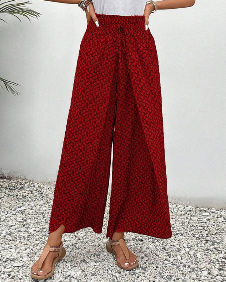 Model wearing red relaxed wide-leg trousers with flat sandals, casual look