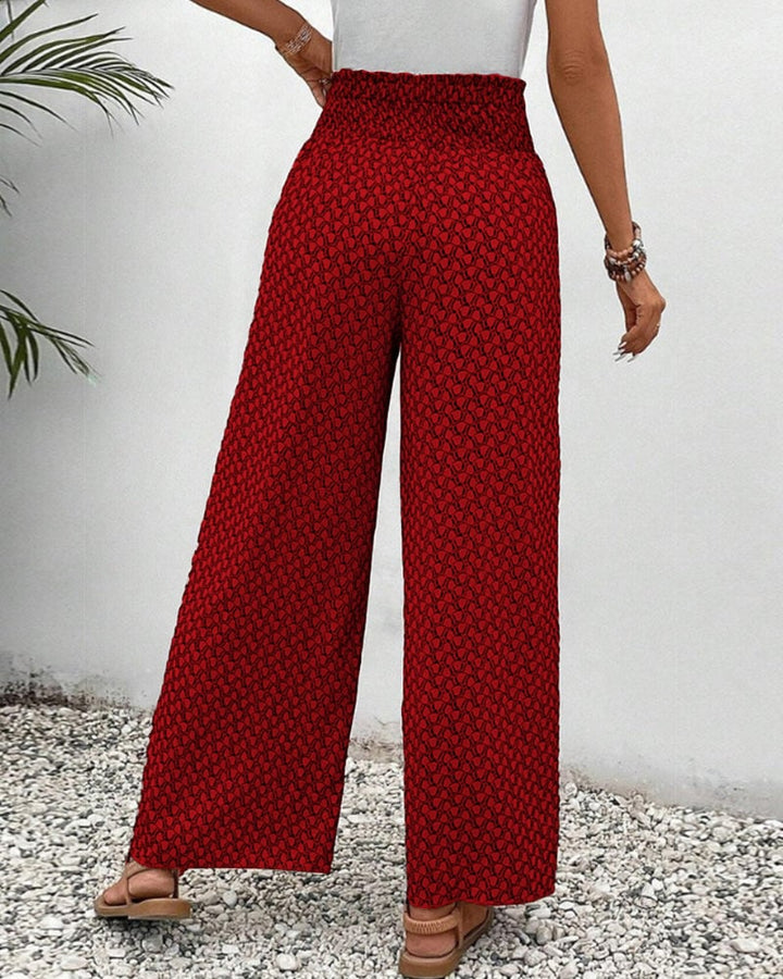 Red wide-leg trousers detail shot highlighting print pattern and waistband