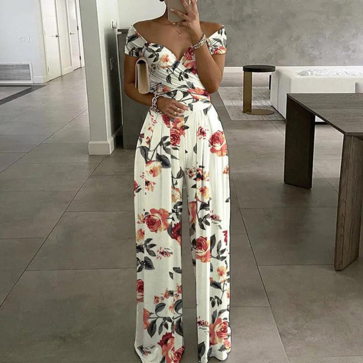 Back view of the Vera botanical-print jumpsuit showing the off-shoulder neckline and wide-leg drape