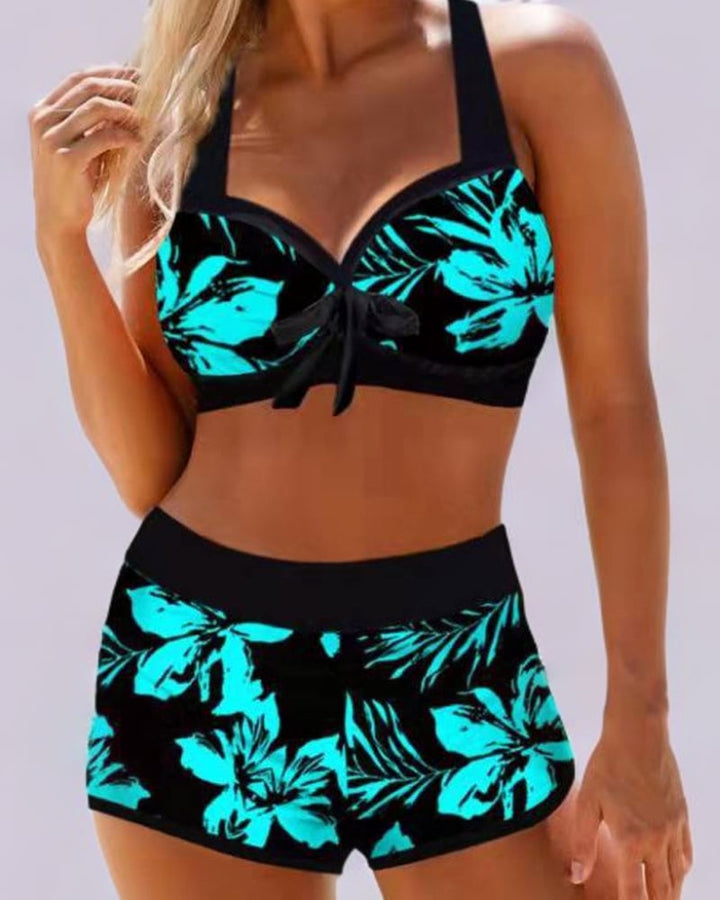 Woman wearing a high waist floral swimsuit in a multicolor print at the beach, front view