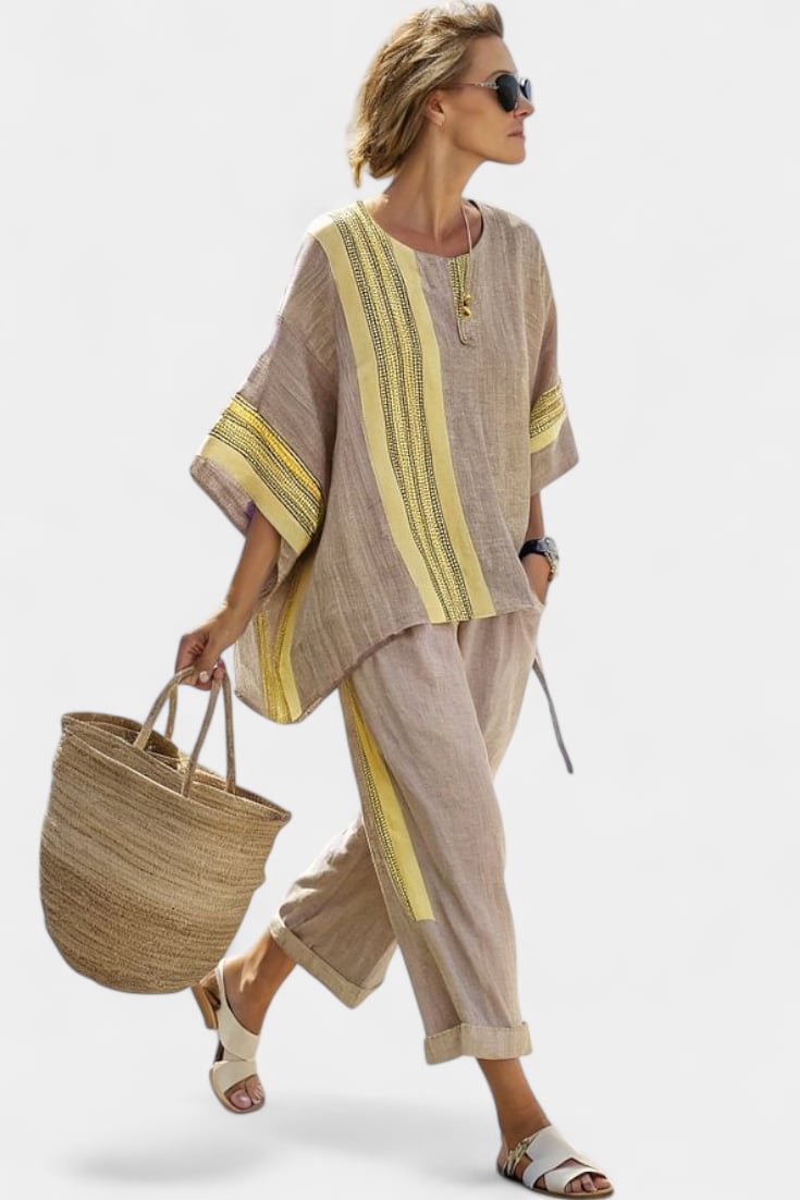 Side view of Via linen tapered pants with rolled cuffs and matching stripe trim, styled with sandals