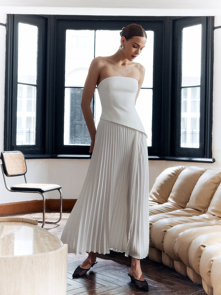 Side view of the Vienna maxi dress in black and white with pleated skirt in motion