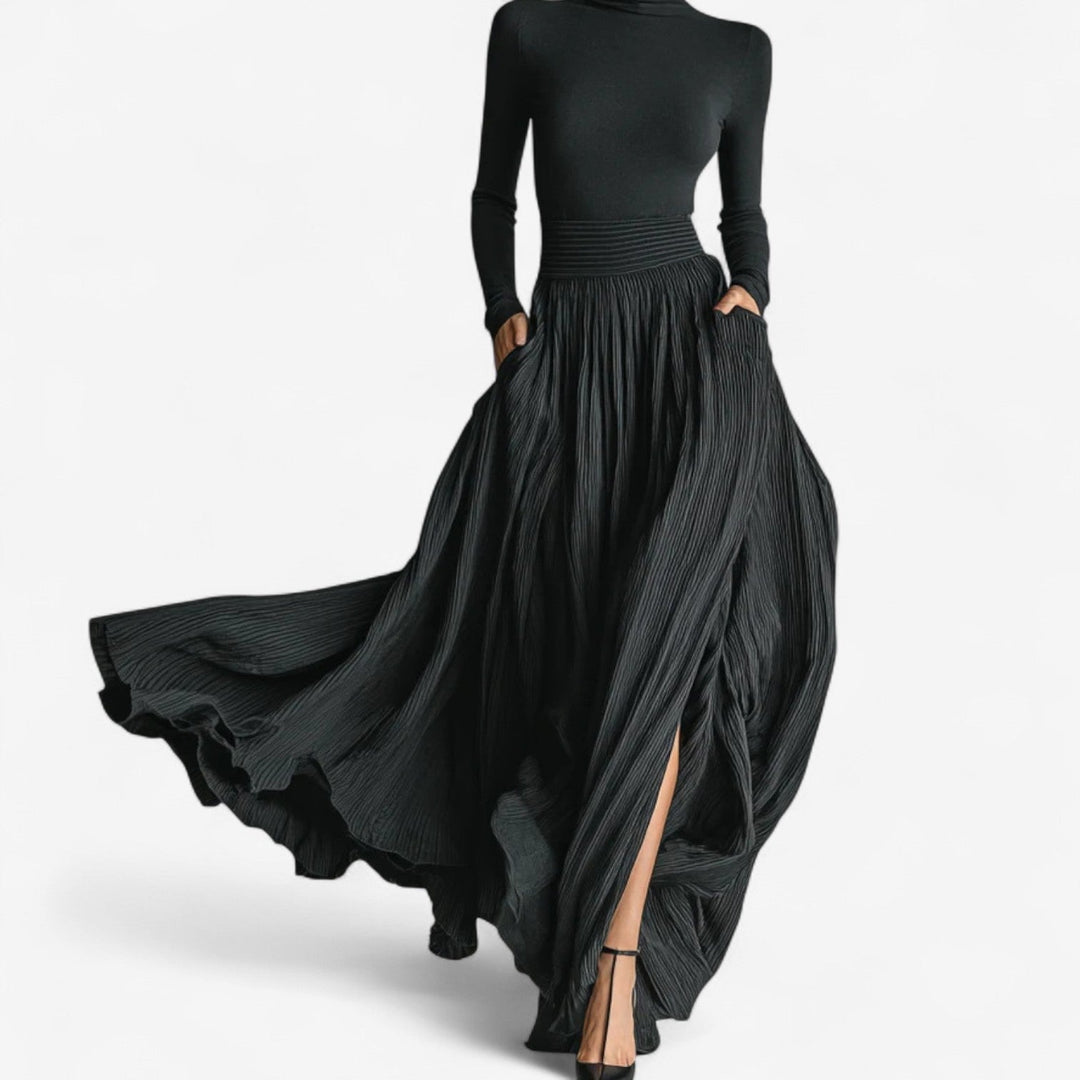 Woman wearing a black flowing maxi high-waist dress, full-length front view showing elegant silhouette