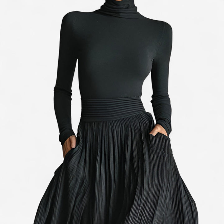 Close-up detail of black maxi dress fabric showing soft, lightweight drape and high waistline