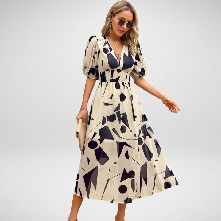 Woman wearing the Violet flowy V-neck dress in Apricot, showing the fitted waist and flowing skirt silhouette
