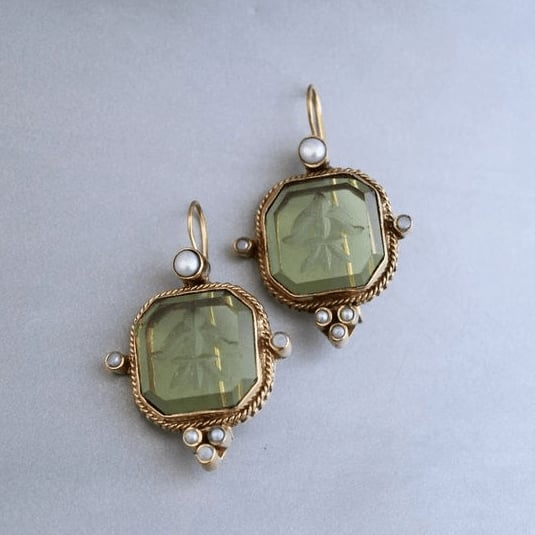 Close-up of vintage green and pearl drop earrings with elegant detailing