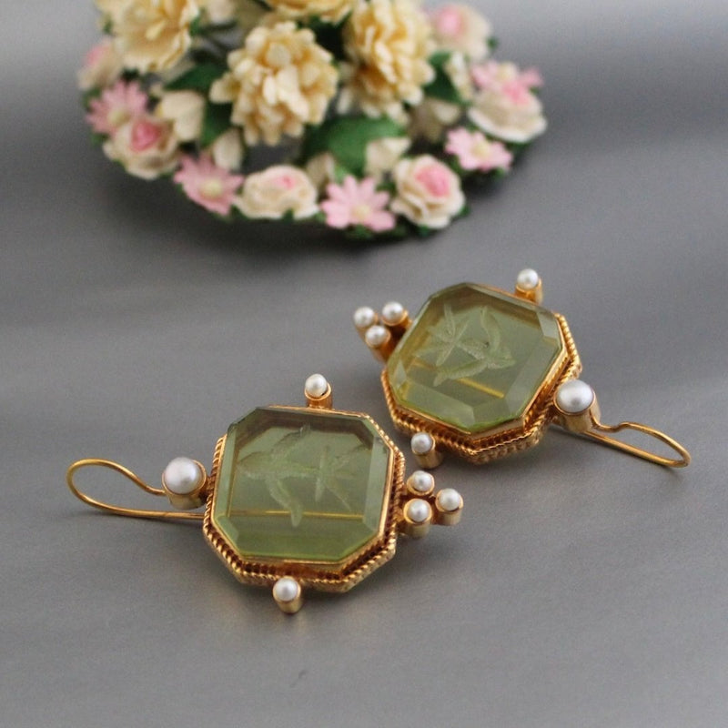 Vintage green and pearl drop earrings styled as a pair on a neutral background
