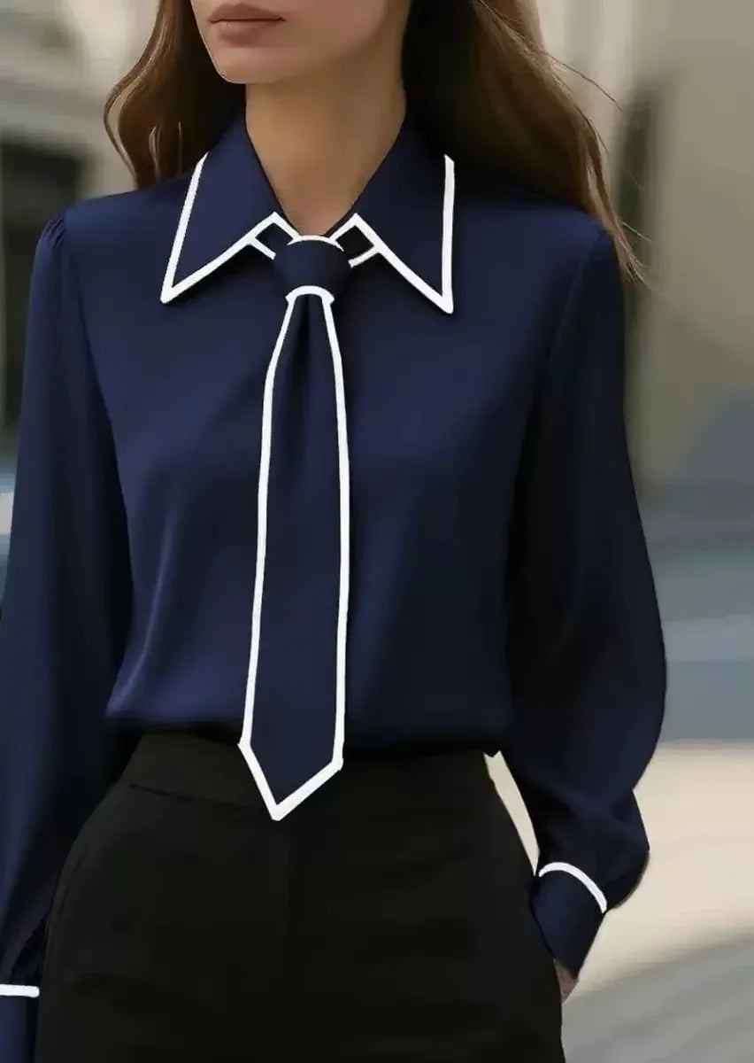 Flat lay of the Vivian tie neck blouse in beige showing contrast piping along collar, cuffs, and front placket
