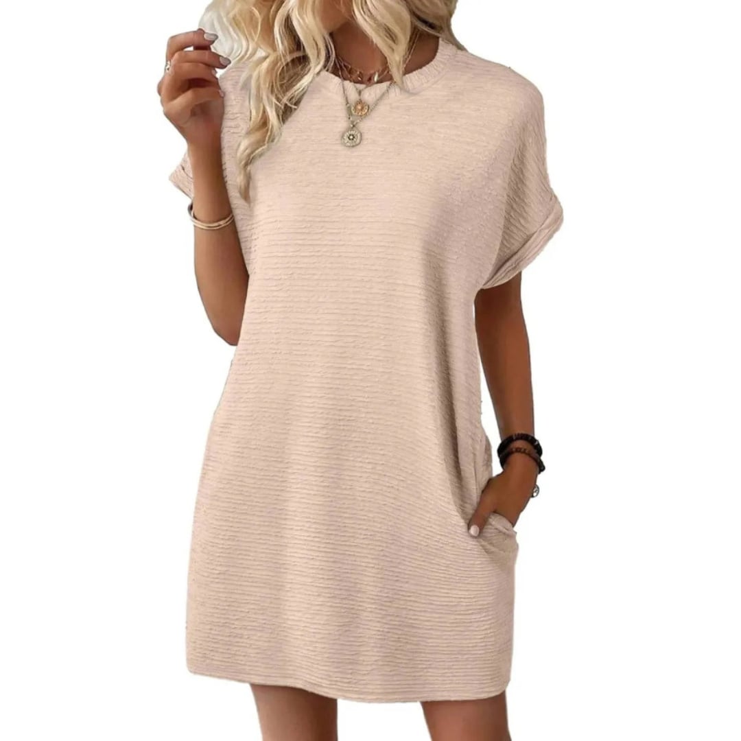 Woman styling the Vivid mini dress in Apricot with gold sandals and layered necklaces