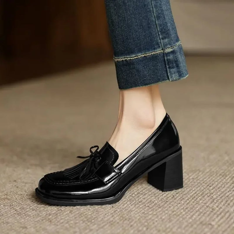 Vivienne tassel loafer pump in glossy black, side profile showing block heel height