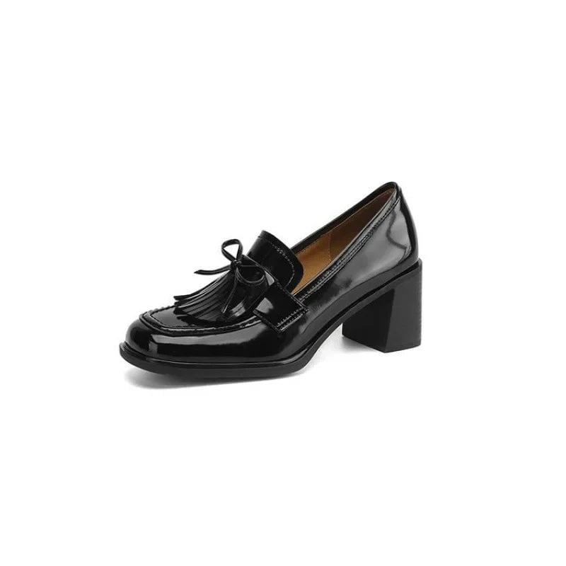 Vivienne tassel loafer pump in glossy black worn on foot, three-quarter angle