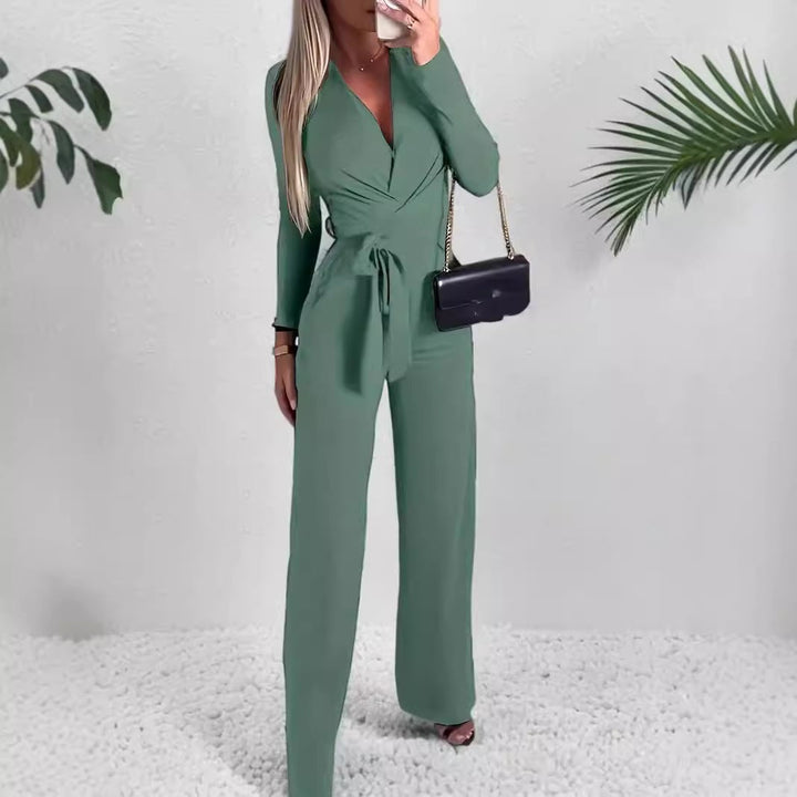 Woman wearing the Vivienne wide-leg jumpsuit in green with a wrap V-neckline and self-tie waist belt