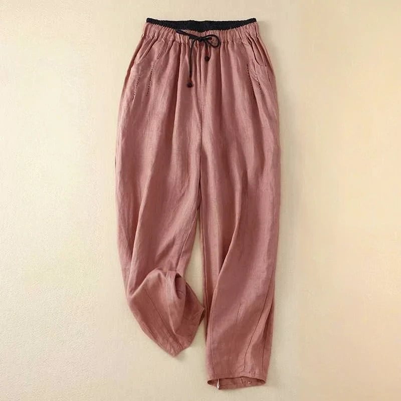 Woman styled in pink relaxed summer pants paired with a white tank top for a casual warm-weather look