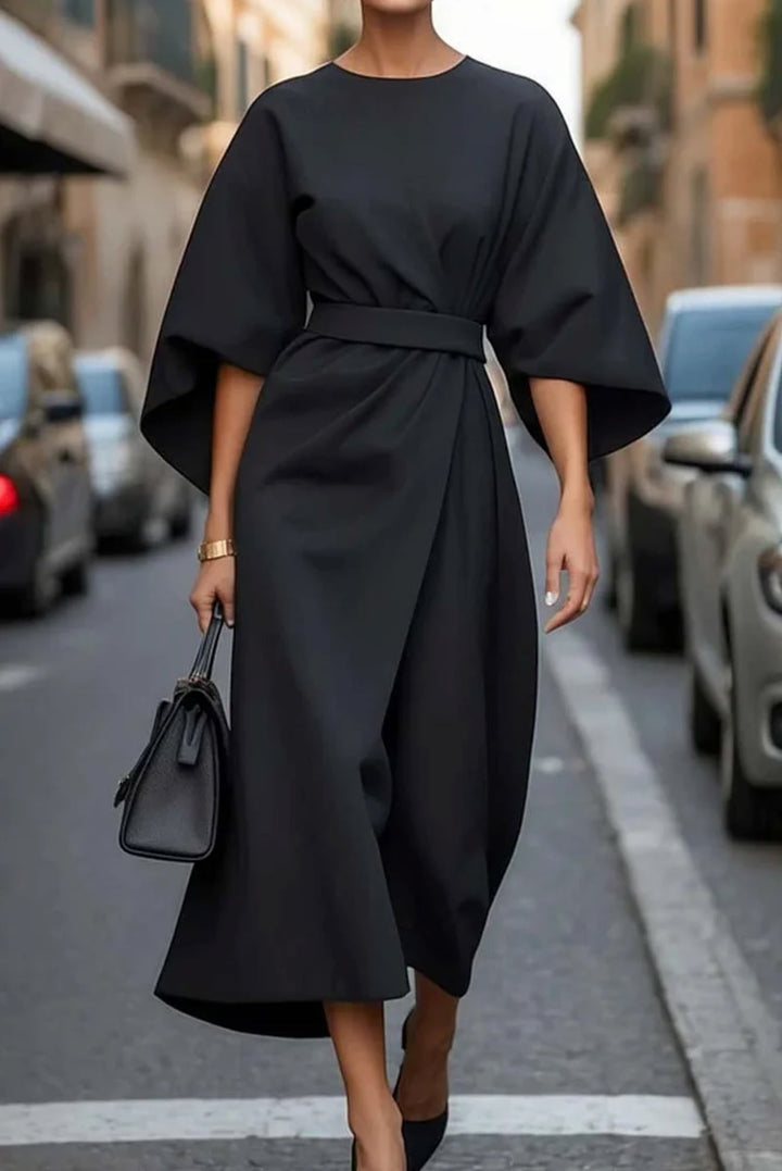 Woman wearing the Wendy elegant lantern sleeve dress in blue with an adjustable waist bow, flowing silhouette
