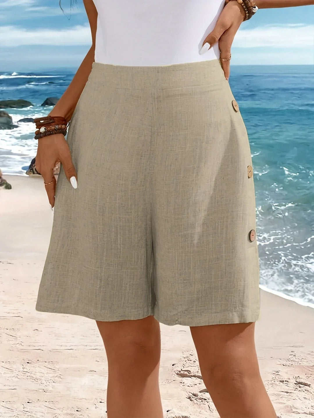 Three-quarter view of breezy button-detail shorts in green on a female model