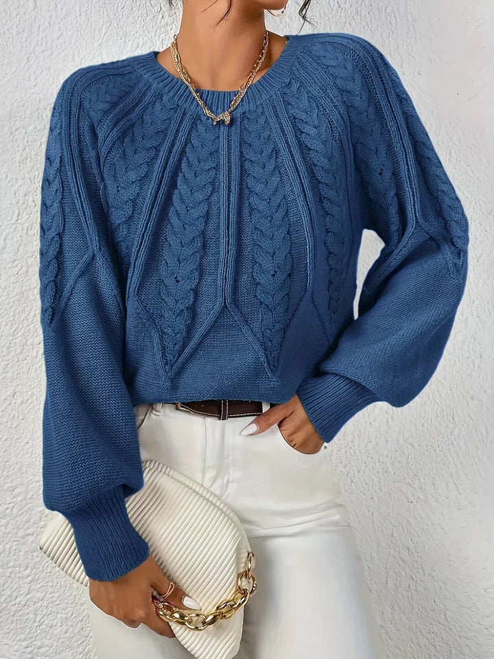 Willow cable-knit sweater shown from the side, emphasizing its relaxed and feminine fit