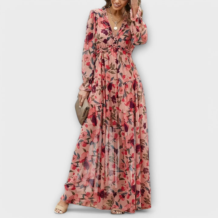 Model wearing a pink floral V-neck maxi dress with a flowing silhouette