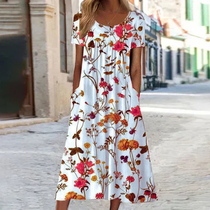 Full-length lifestyle shot of a woman in a floral short sleeve midi dress styled for a summer occasion