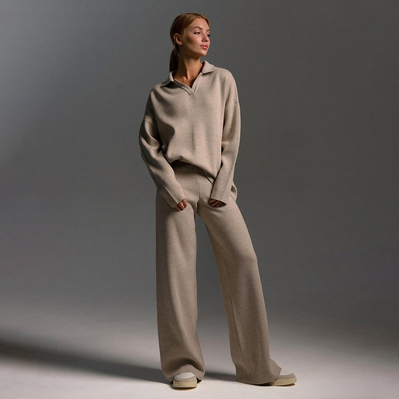 Woman wearing a soft knitted two-piece tracksuit set with wide-leg pants and a relaxed pullover top in a neutral color