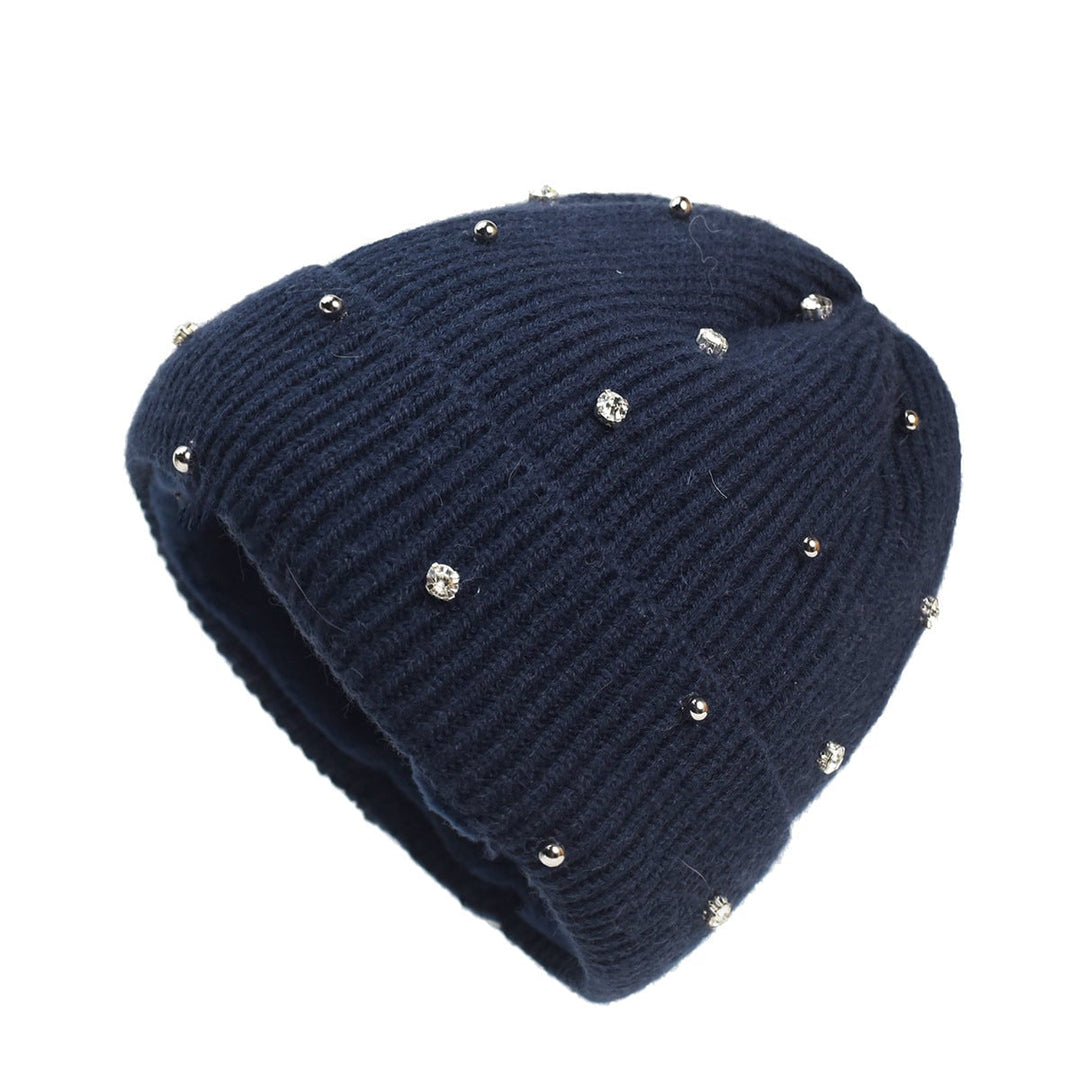 Woman wearing a subtle sparkle knit beanie in navy blue against a winter background