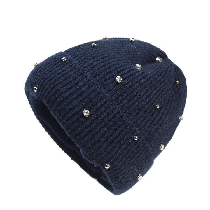 Woman wearing a subtle sparkle knit beanie in navy blue against a winter background
