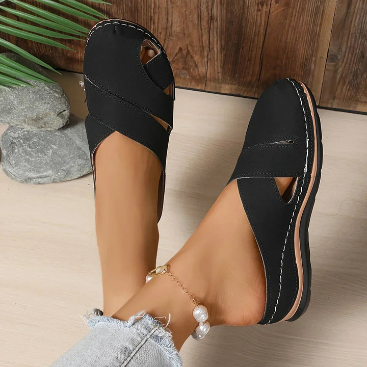 Women's platform wedge sandals in black showing round-toe silhouette and wedge lift, side view