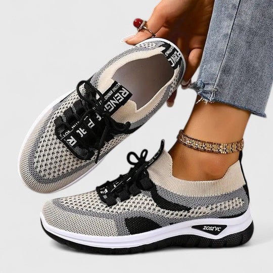 Women's mesh sneakers displayed on clean white background highlighting graphic lace-up detail