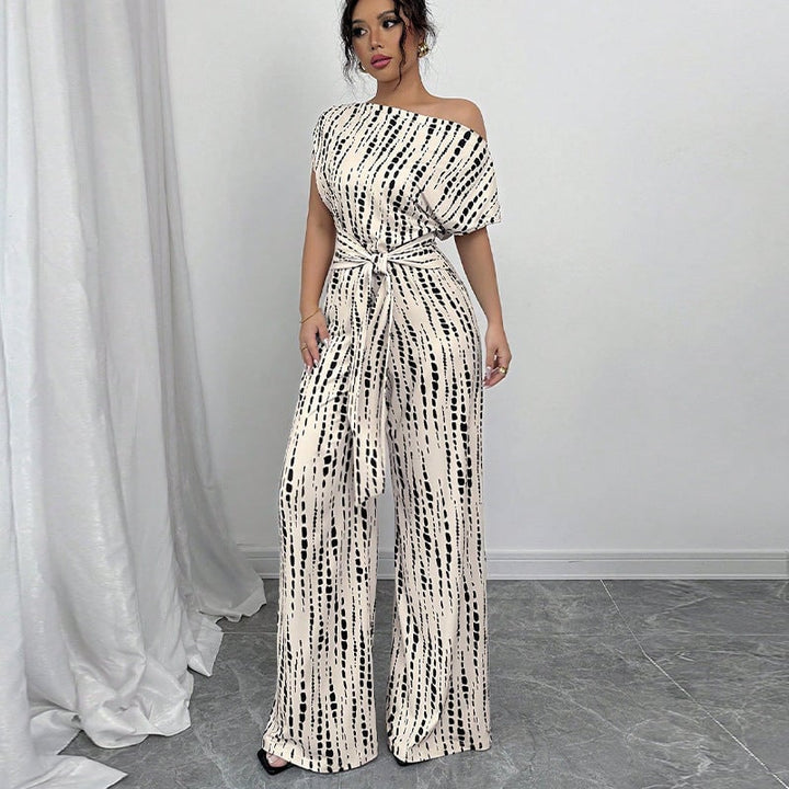 White printed wide-leg one-shoulder belted jumpsuit with black and cream abstract dot pattern, front view