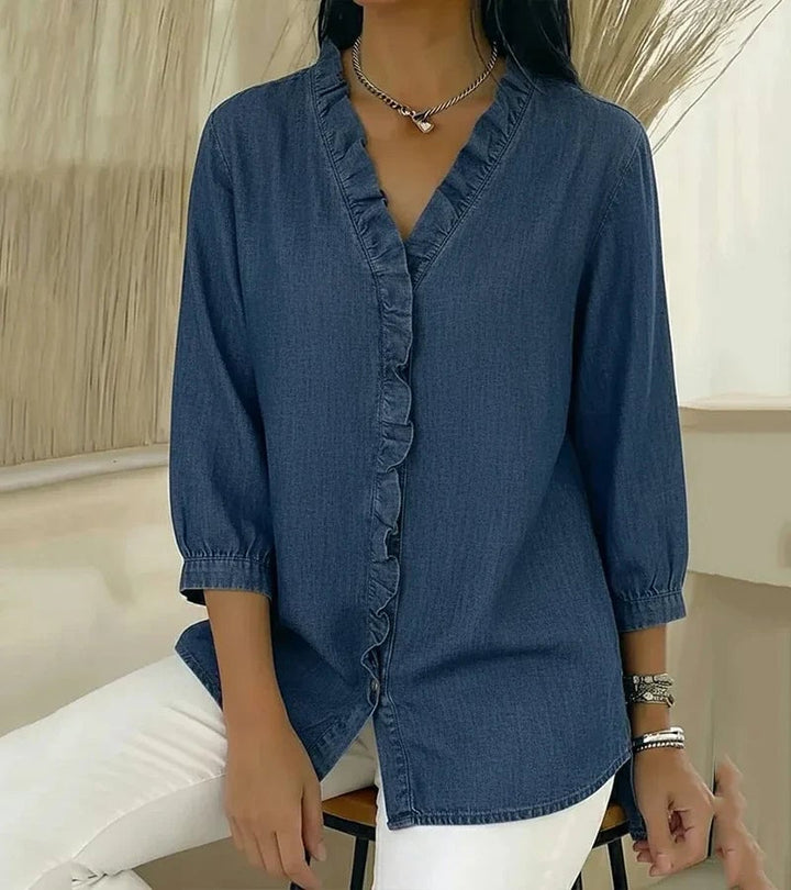 Model styled in ruffle V-neck blouse in blue paired with high-waisted trousers