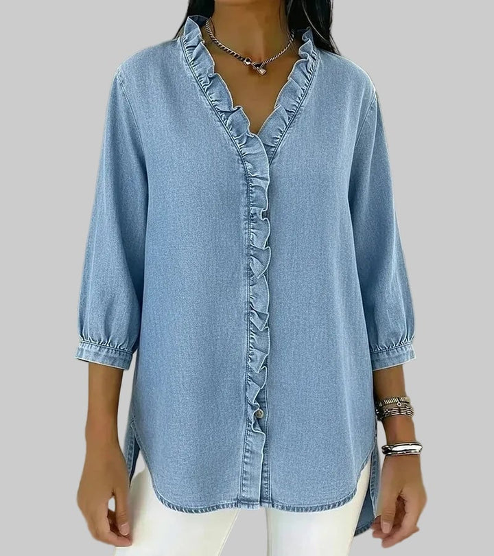 Detail shot of ruffle V-neckline on blouse in apricot against a neutral background