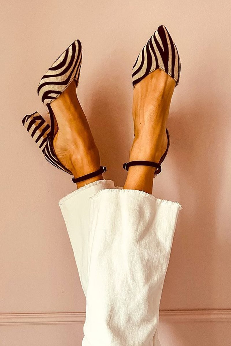 Khaki zebra print sandals with ankle strap and mid heel on a clean background