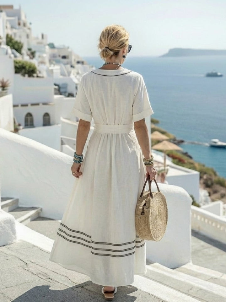 Close-up of the adjustable wrap tie and deep V-neckline detail on a white midi dress