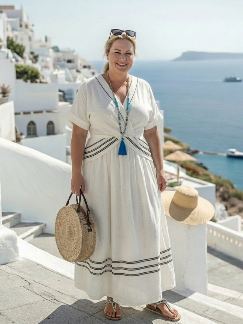 Side view of a woman in a white short-sleeve wrap midi dress showing midi length and relaxed drape