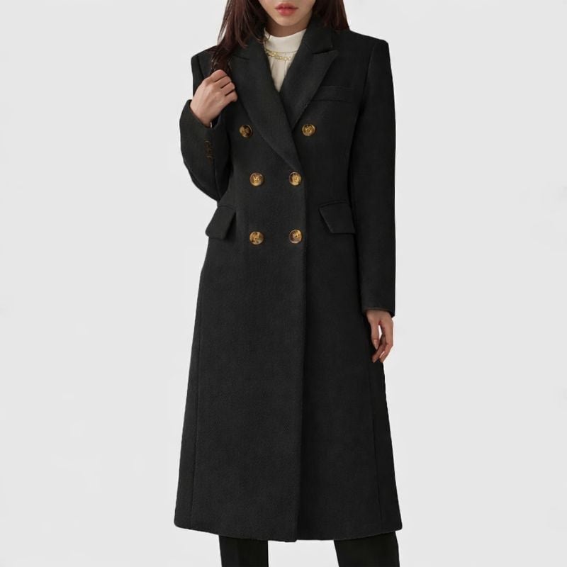 Woman styled in the Ziva overcoat in black paired with heeled boots for a polished evening look