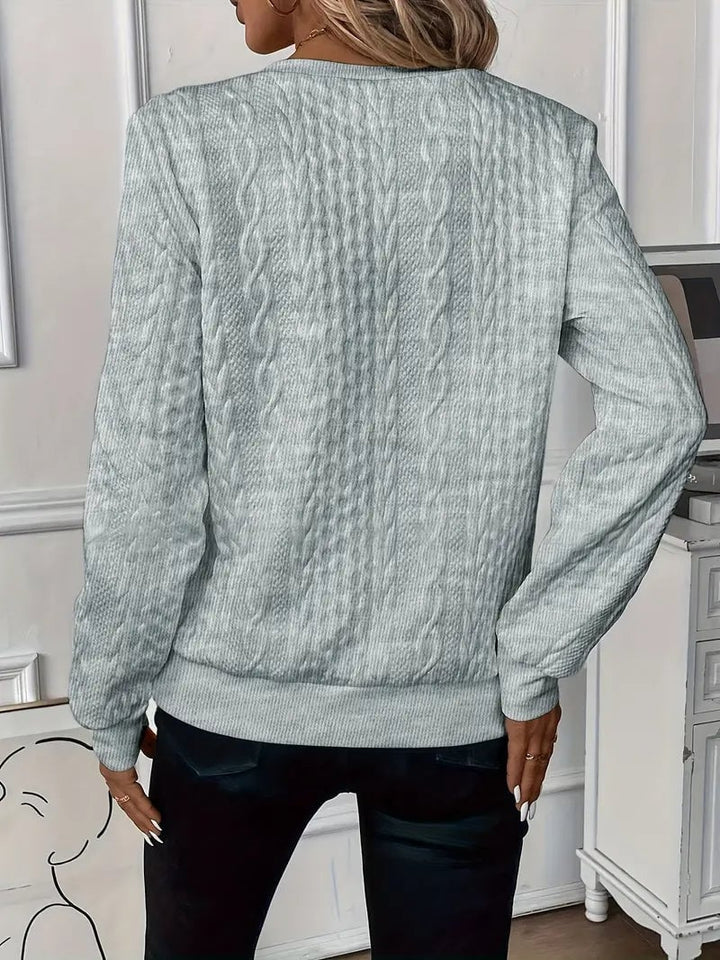 Woman layering a zip-up cable knit sweater over a casual outfit