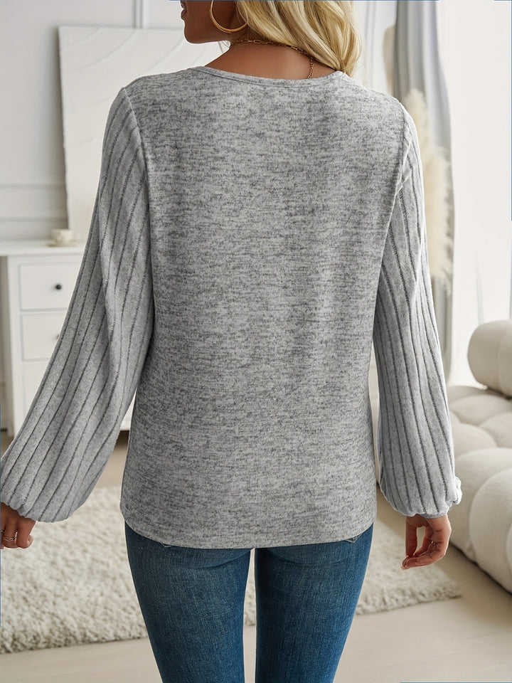 Woman in a blue lantern sleeve sweater paired with tailored trousers for a chic work outfit