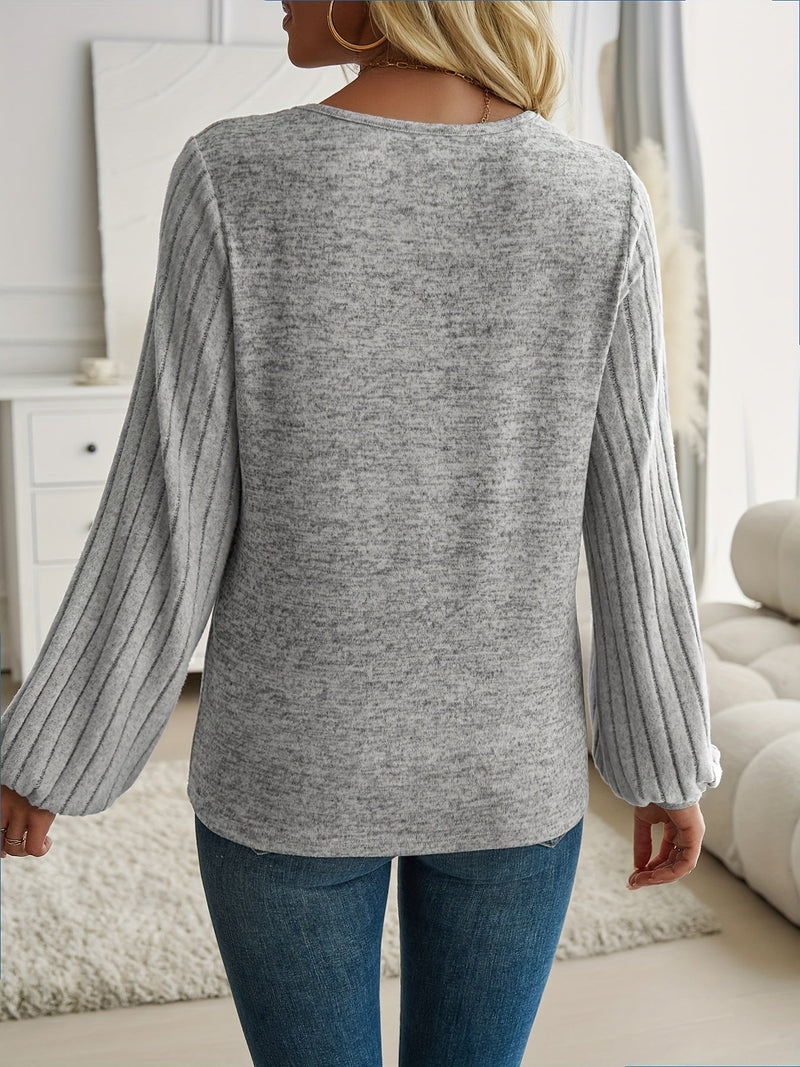 Woman in a blue lantern sleeve sweater paired with tailored trousers for a chic work outfit