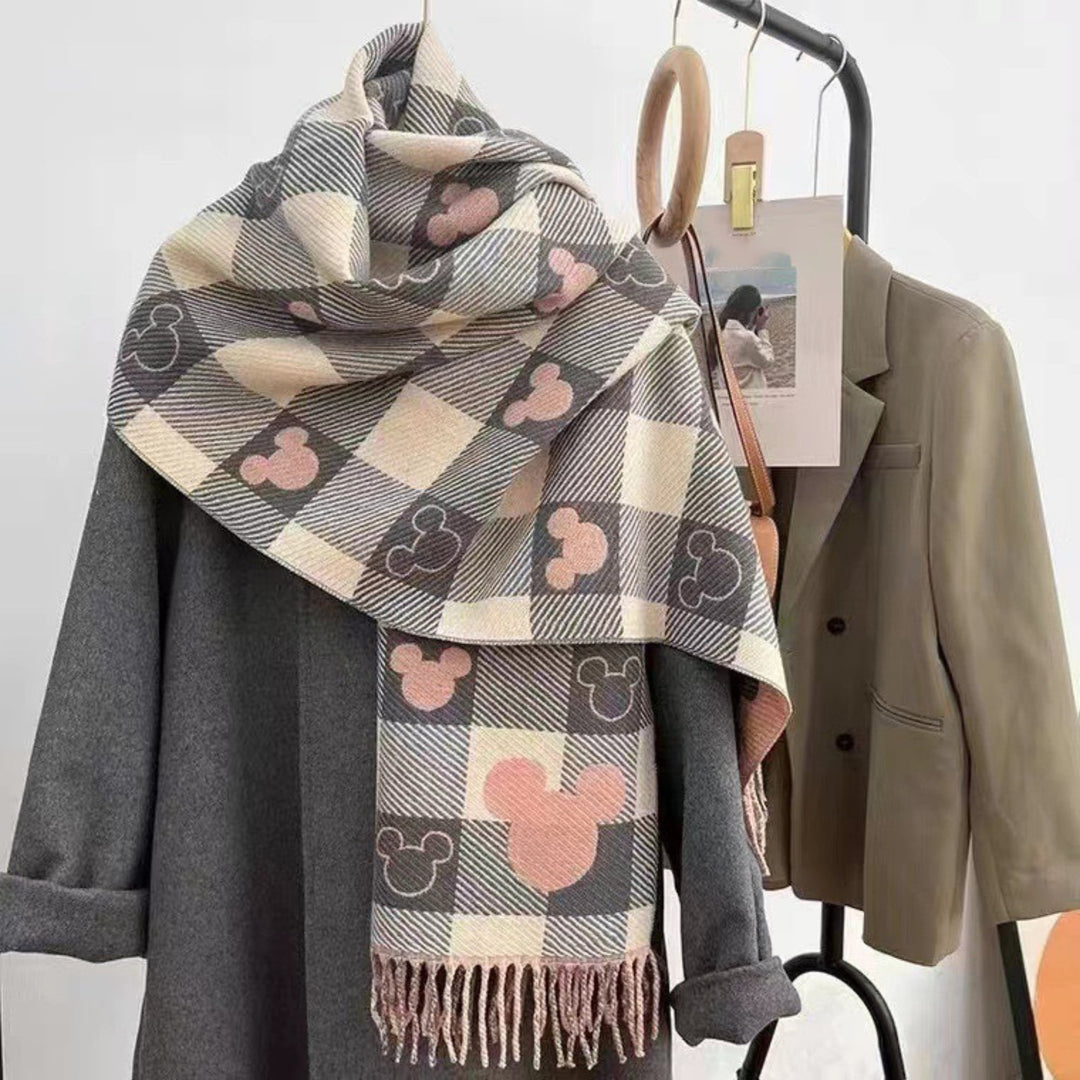 Woman wearing a reversible double-sided plaid tassel scarf in Mickey Gray draped over her shoulders